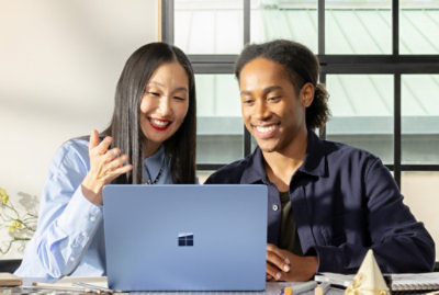 A man and women looking at the laptop screen and discussing