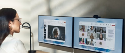 A woman sitting at a desk looking on the screen.