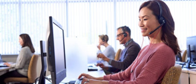 A woman and some people beside her working on the laptop