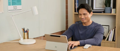 A man sitting at a desk using a laptop.