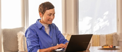 A woman sitting in office environment and looking at the screen