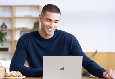 A man smiling and looking at the laptop