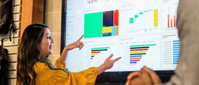 A person pointing at a screen displaying information.