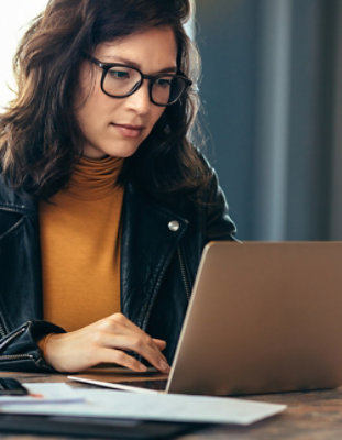 A person wearing glasses using a laptop