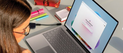 A woman wearing glasses looking at the screen.