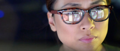 A close-up of a person's face wearing glasses.