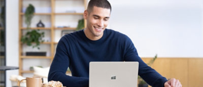 A man sitting at a table with a laptop.