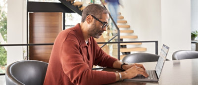 A person sitting at a table using a laptop.