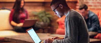 A man with glasses working on the laptop