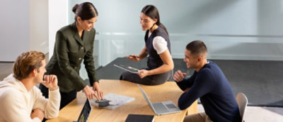 A group of people sitting around a table with a computer keyboard visible.