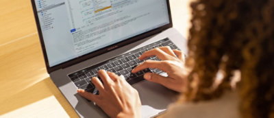 Hands typing on a laptop keyboard.