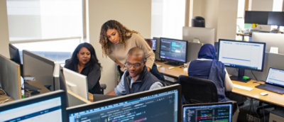A group of people in a room with computers