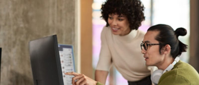 Two people loking at the screen and discussing