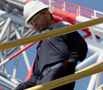 A man wearing a white hard hat and glasses.