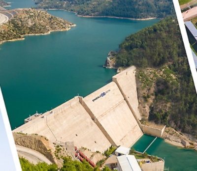 An aerial view of a large concrete dam and a body of water.
