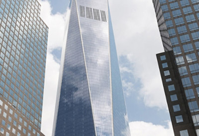 A low angle view of a tall skyscraper against a blue sky.