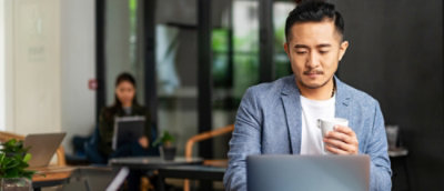 A man sitting at a table with a laptop.