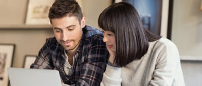 A man and woman looking at a computer screen.