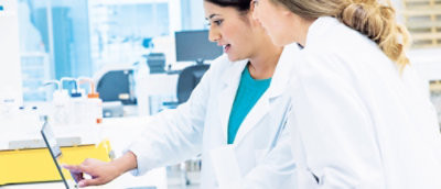 Tampilan jarak dekat seseorang mengenakan jas lab putih.