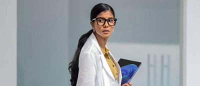 A woman in glasses holding a Tablet.