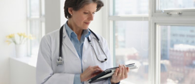 A doctor holding a tablet.