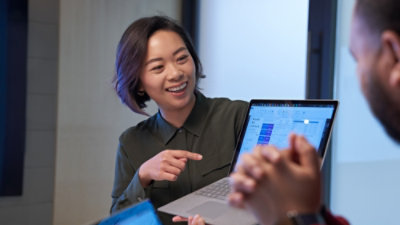 Una persona señalando a un portátil.