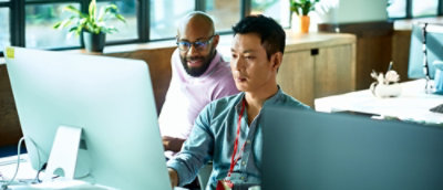 Two individuals looking at the screen with attention