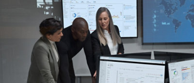 Three people discussing while looking at the screen