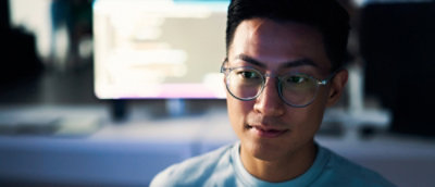 A man wearing glasses looking down