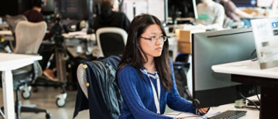 A woman wearing glasses working in the office setup