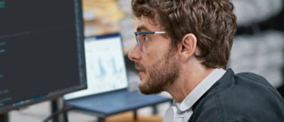 A man wearing glasses looking at the screen