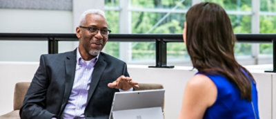 Two people talking to each other while looking at the screen.