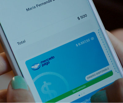 A person holding a phone displaying a Mercado Pago account screen