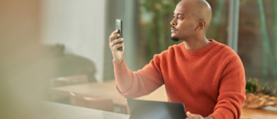 A man take a selfi on his mobile.