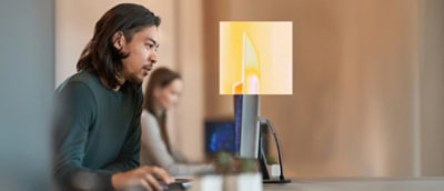 A man and a women working on desktop in office.