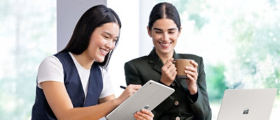 A couple of women looking at a tablet.