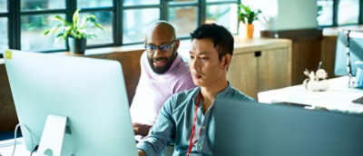 A group of men looking at a computer screen.