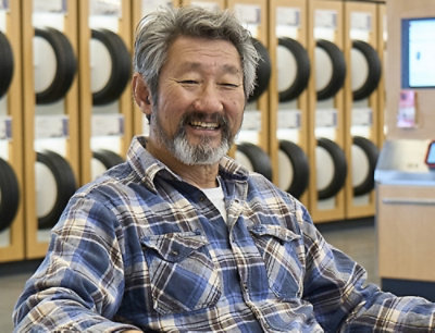 A man sitting in front of a wall of tires.