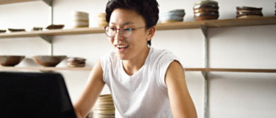 A person with short hair wearing glasses and a white shirt.
