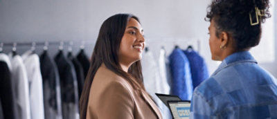 A woman smiling while holding a tablet.