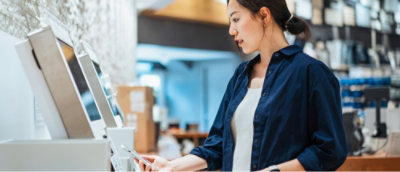 A woman wearing a blue shirt looking at a phone.