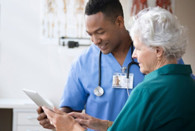 A doctor and a patient looking at a tablet.