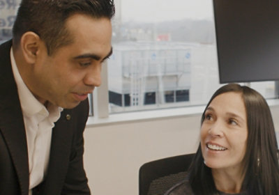 A man and woman working together at a desk in an office.