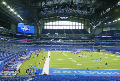 A large stadium filled with spectators surrounding a vast green field during an event.