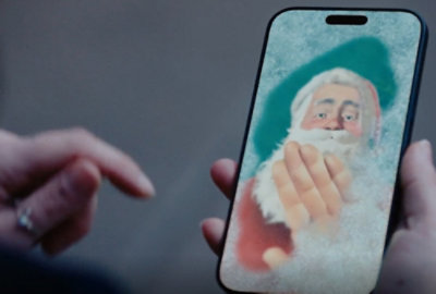 A person holds a phone displaying a festive Santa Claus image.