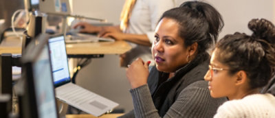 Two women looking towards screen