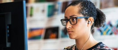 En kvinna med glasögon och hästsvans.