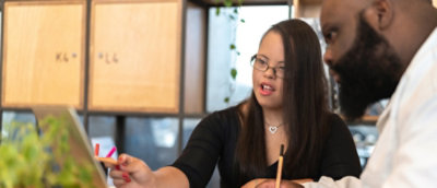 一位女士指向笔记本电脑屏幕