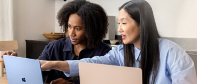A couple of people looking at a laptop.