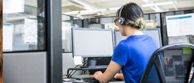 A person wearing headphones and sitting at a computer.